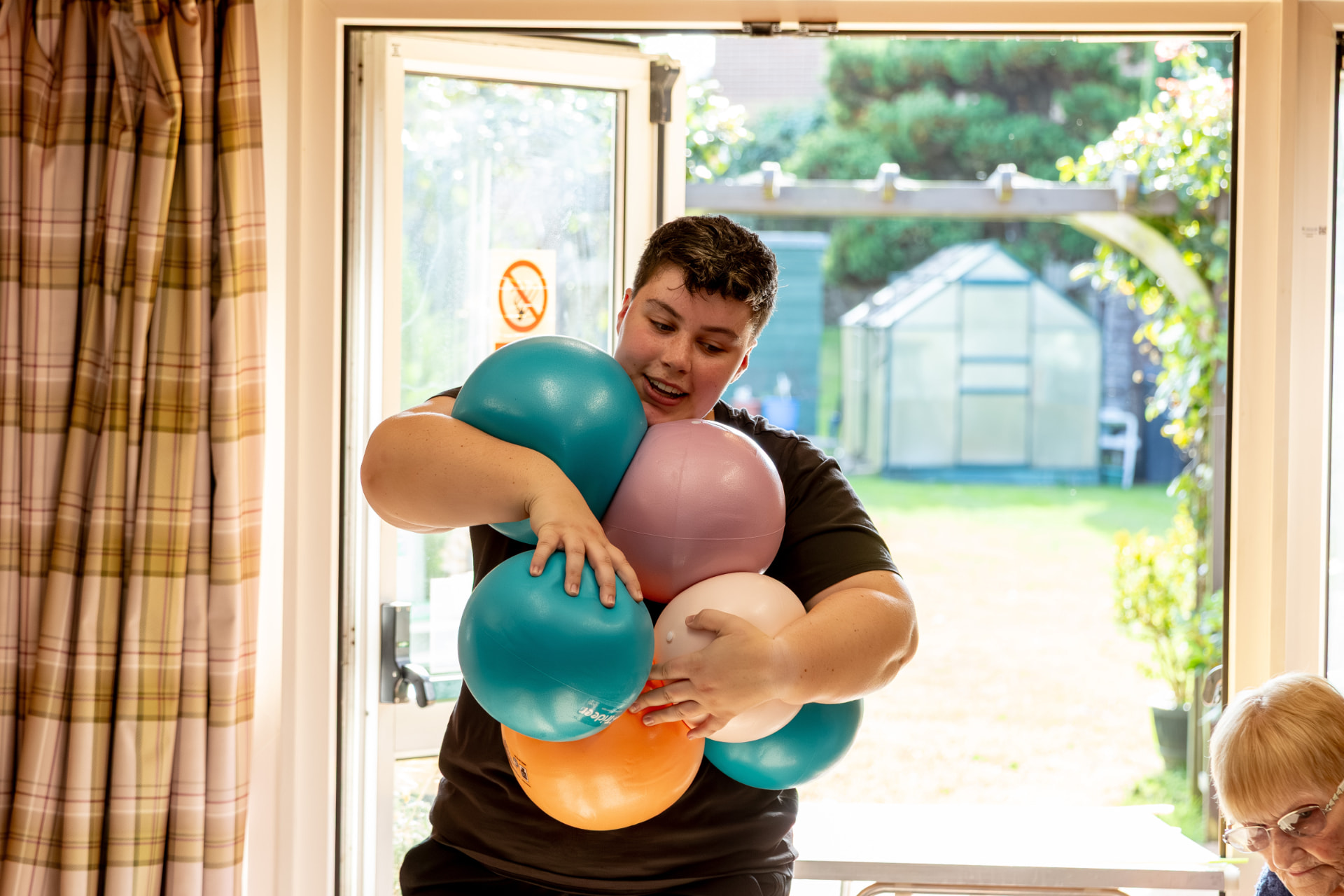 Ellie carrying an armful of colourful exercise balls